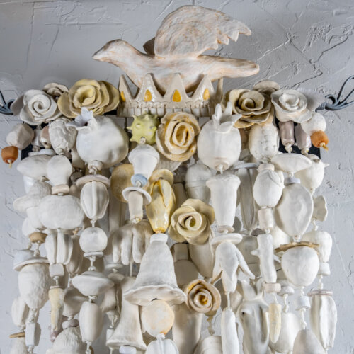Video of a hanging amulet named The White King (2023) consisting of several strands of clay objects painted in various shades of white and off-white in the studio of Oklahoma born mixed-media artist Paul Medina.