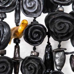 A close-up detail of the multi-strand mixed-media amulet "Night Roses" by Oklahoma artist Paul Medina. Night Roses is 19 x 50 inches and made of clay. string, wood, and steel.