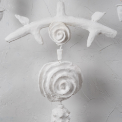 A close-up detail of the mixed-media single strand amulet "White" by Oklahoma artist Paul Medina. White is 22 x 70 inches and made of clay. string, wood, and steel.