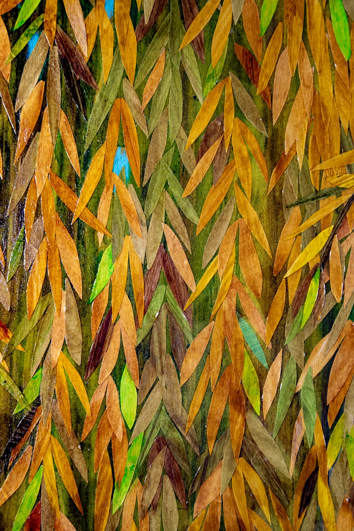 A close up view of a section of Wading Through The Willows is a 36" x 36" mixed media piece of  painted paper collage on canvas. It pictures a young woman with dark hair, wearing a yellow dress, surrounded by a drape of willow branches against a blue sky, surrounded by a thick drape of golden yellow and green willow branches against a blue sky.