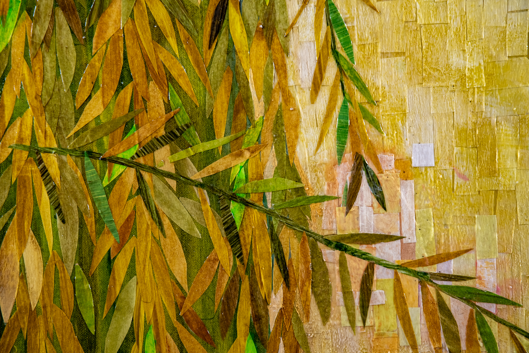 A close up view of a section of Wading Through The Willows is a 36" x 36" mixed media piece of  painted paper collage on canvas. It pictures a young woman with dark hair, wearing a yellow dress, surrounded by a drape of willow branches against a blue sky, surrounded by a thick drape of golden yellow and green willow branches against a blue sky.