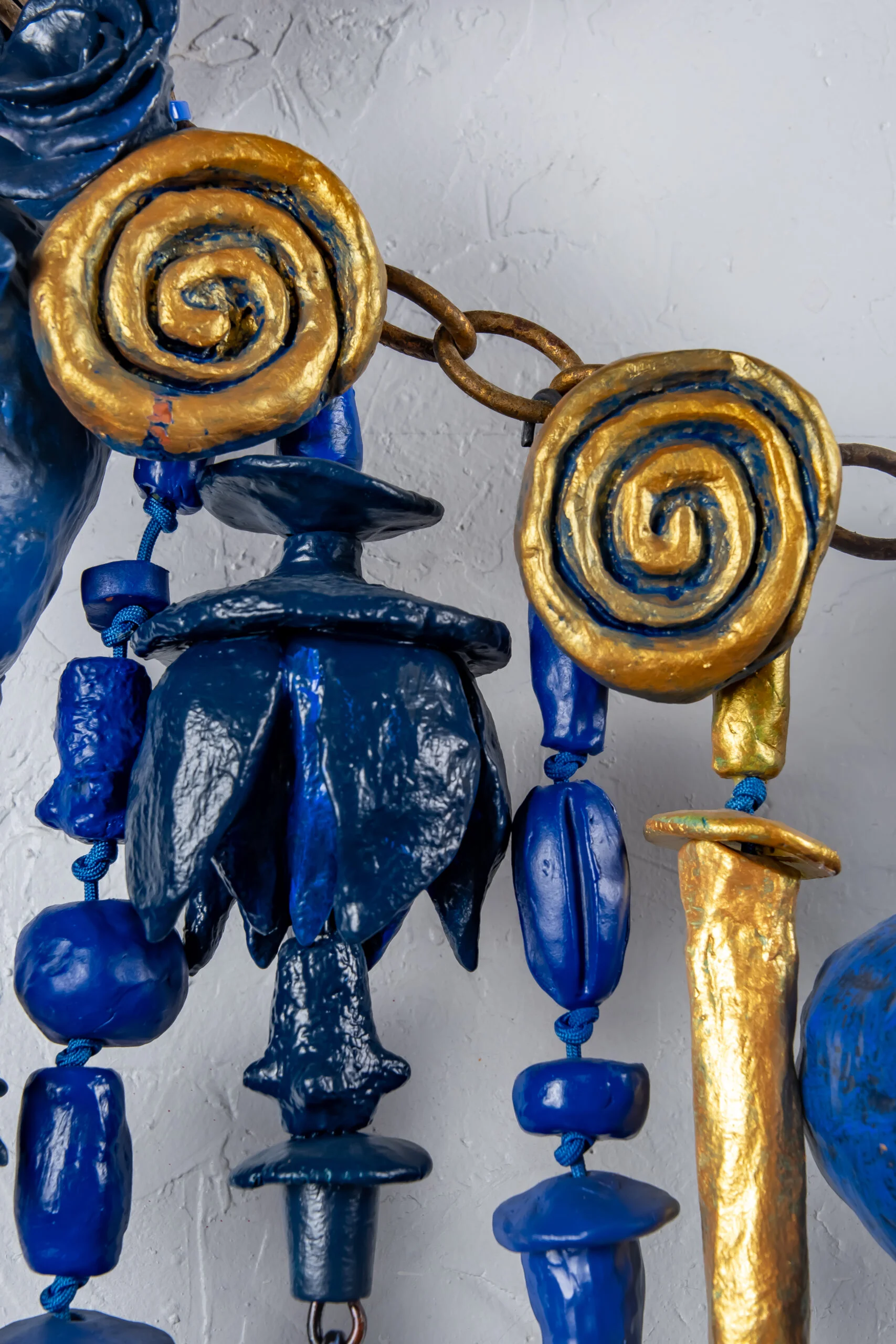 Close up detail of Sparks At Night. Sparks At Night is a 34" x 40" mixed media wall-hanging amulet by Oklahoma born mixed-media artist Paul Medina. Sparks at Night is a mixed media amulet made from low fired clay, with mixed media, nylon cord, and steel.