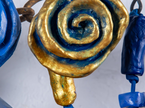 Close up detail of Sparks At Night. Sparks At Night is a 34&quot; x 40&quot; mixed media wall-hanging amulet by Oklahoma born mixed-media artist Paul Medina. Sparks at Night is a mixed media amulet made from low fired clay, with mixed media, nylon cord, and steel.