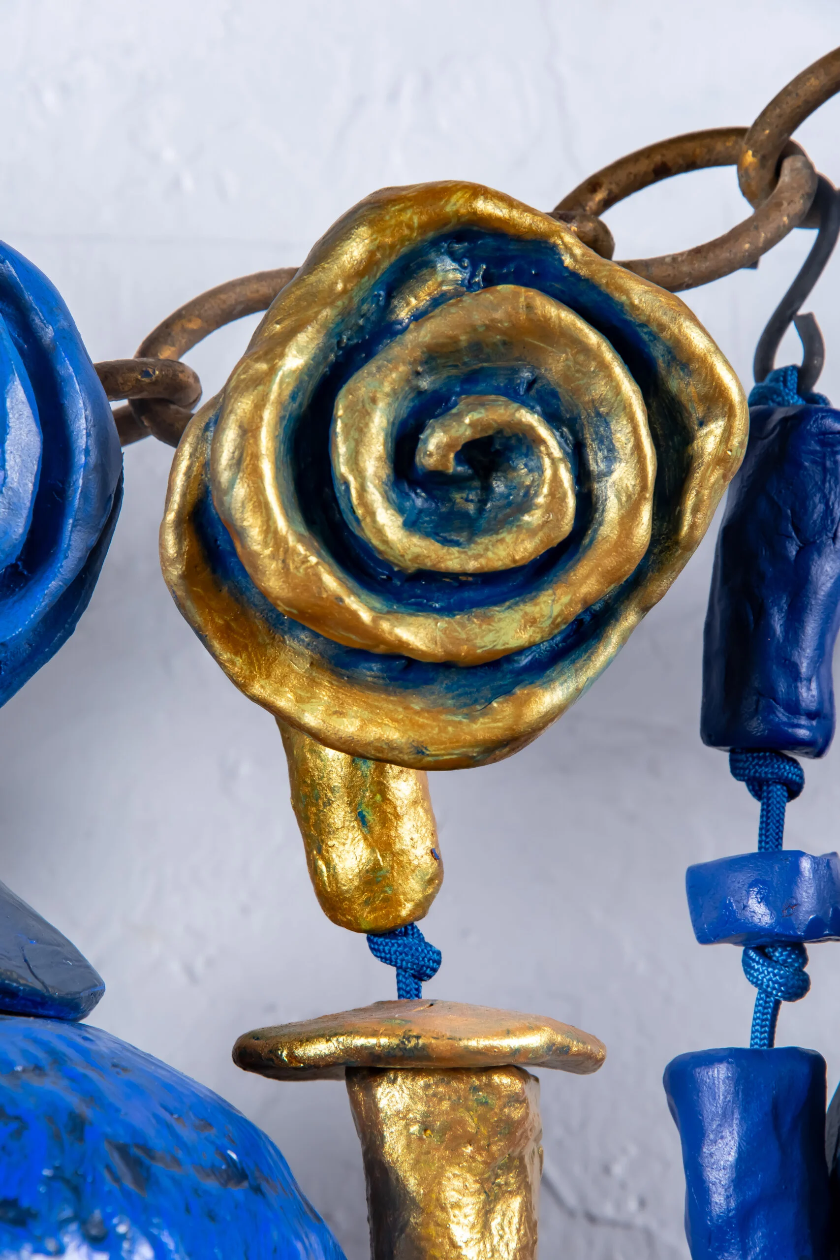 Close up detail of Sparks At Night. Sparks At Night is a 34" x 40" mixed media wall-hanging amulet by Oklahoma born mixed-media artist Paul Medina. Sparks at Night is a mixed media amulet made from low fired clay, with mixed media, nylon cord, and steel.