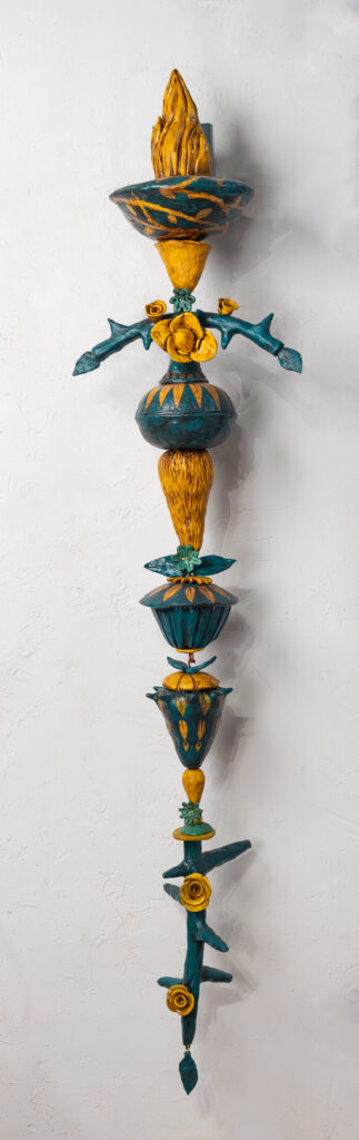 Pictured is "Ray of Hope," a mixed media artwork by Oklahoma artist Paul Medina, featuring a vertical sculpture with teal and gold floral and geometric elements against a textured white background