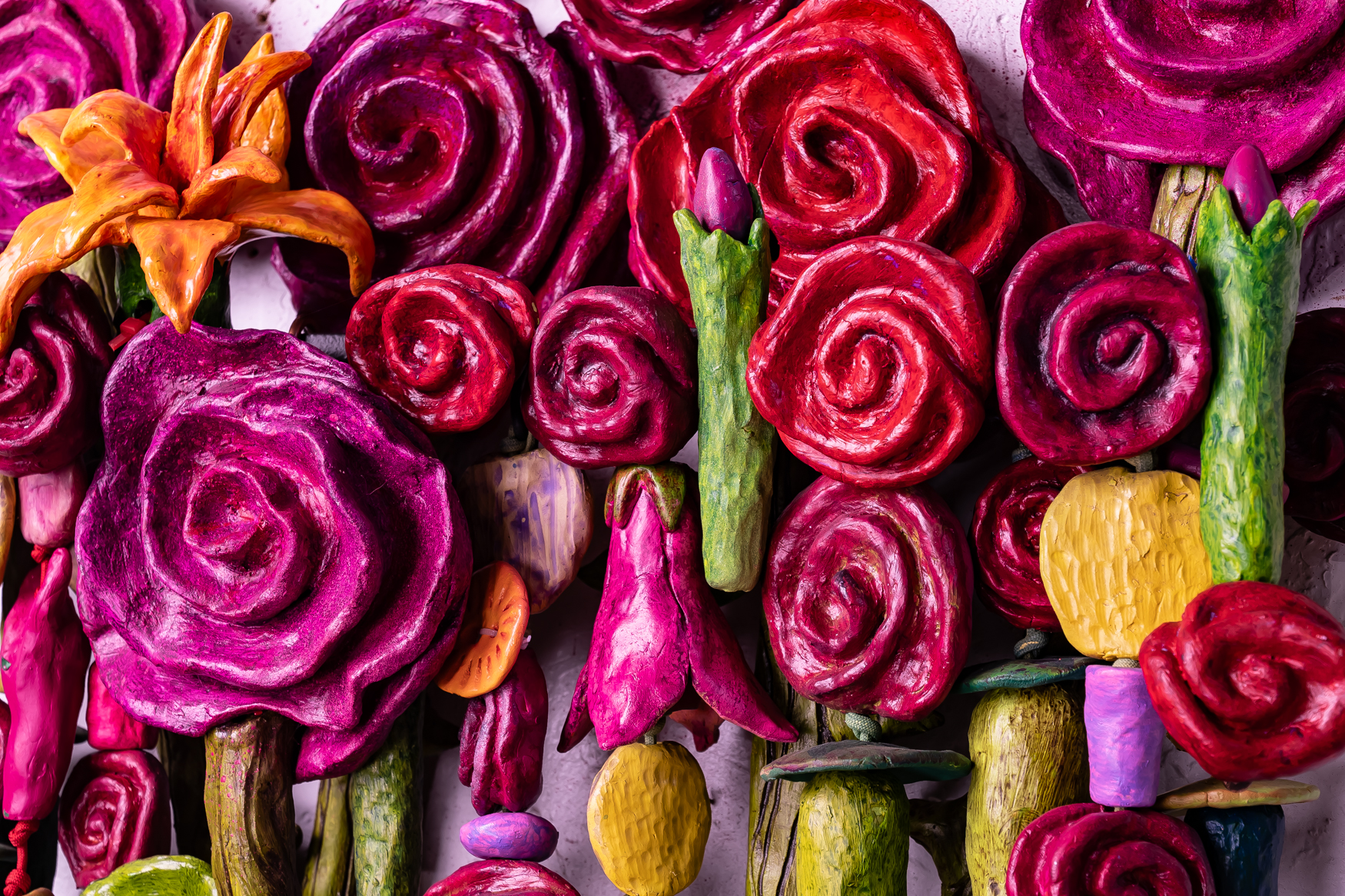 Close-up of vibrant, abstract roses and other flowers in red, pink, and orange hues from the mixed media artwork "Bouquet For Grace" by Oklahoma artist Paul Medina.