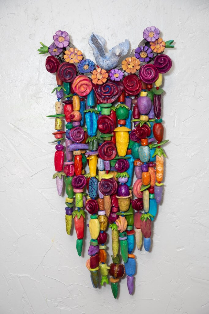 Perch (2025) is a 14" x 33" x 7" a mixed media amulet on fired clay, steel, copper and nylon cord.