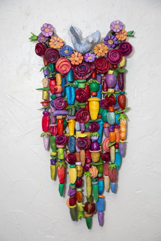 Perch (2025) is a 14" x 33" x 7" a mixed media amulet on fired clay, steel, copper and nylon cord.