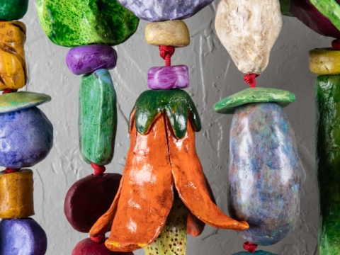 THINKING OF YOU (2025) is a 5'x5'x9" wall amulet made of mixed media on low-fired clay, steel, copper and nylon cord.